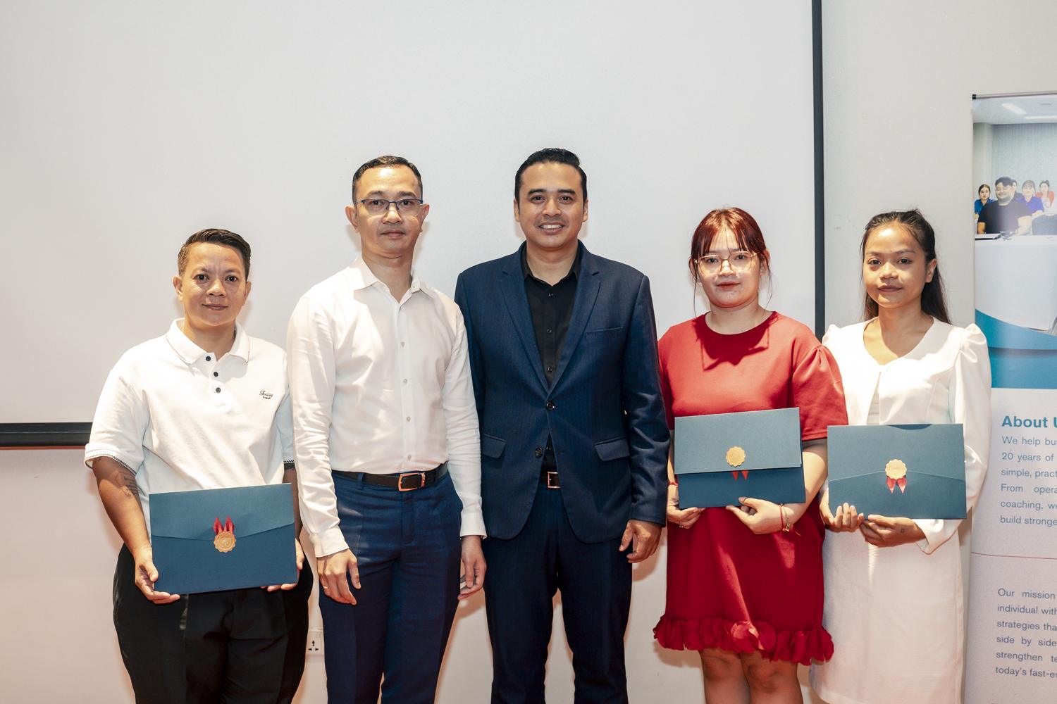 Graduates receiving certificates from the lead trainer